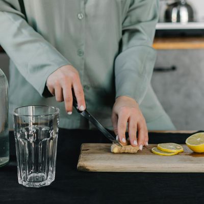 A glass of water with lemon next to a yoga block.